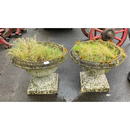 1271 - A pair of reconstituted stone planters on stepped plinths