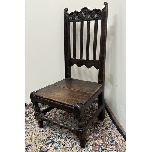 480 - C18th oak back stool with scroll carved cresting and solid seat on turned supports