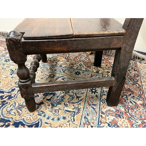 480 - C18th oak back stool with scroll carved cresting and solid seat on turned supports