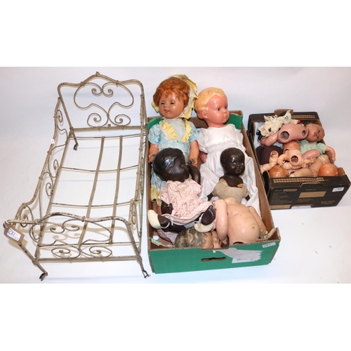 281 - Collection of mid C20th plastic and composition dolls and doll parts, doll clothing, and a doll bed ... 