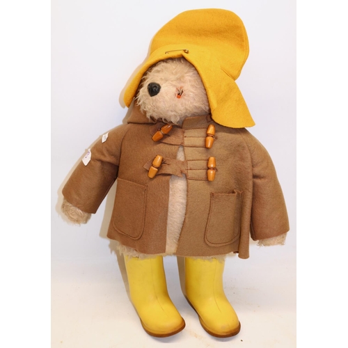 493 - A Gabrielle designs Paddington bear with brown duffle coat, yellow hat and rain boots, Height approx... 