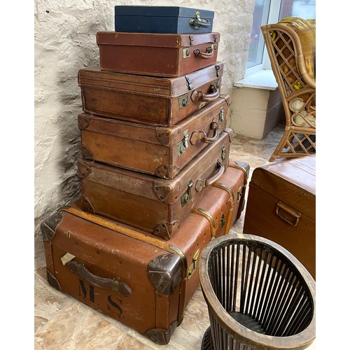 347 - Collection of suitcases, scumbled tin trunk, an initialed wood bound trunk, and a waste paper basket... 