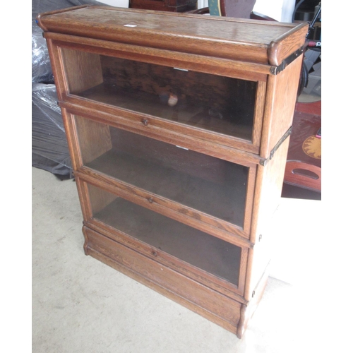 576 - C20th oak Globe-Wernicke three tier book case, with glazed doors on plinth base, W87cm D28cm H116cm