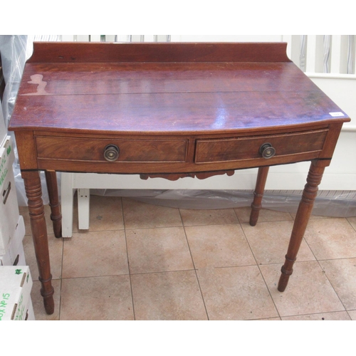 682 - Victorian mahogany two drawer bow front side table on turned supports and small raised back, W92cm