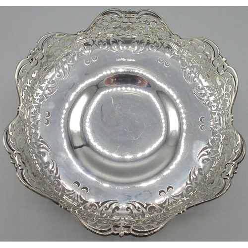 1043 - George V silver circular fruit bowl, with scroll and leaf pierced waived border on scroll cast base,... 