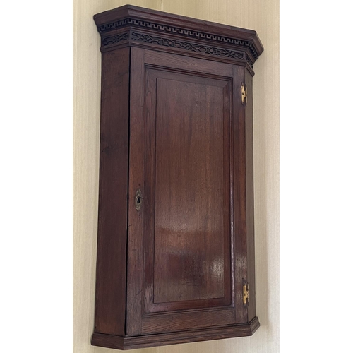 1351 - George III oak corner cupboard, with Greek Key cornice and blind fret frieze above a raised and fiel... 