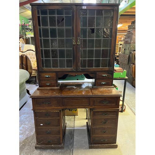 436 - Edwardian oak kneehole writing cabinet, two lead coloured glass doors above hinged writing service w... 