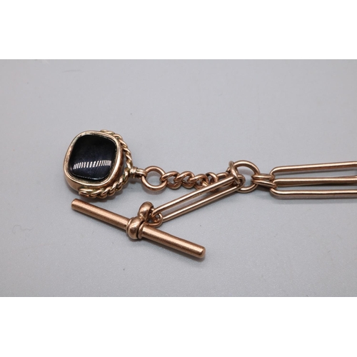 1017 - 9ct yellow gold long link Albert with attached 9ct gold swivel fob set with carnelian and onyx, stam... 