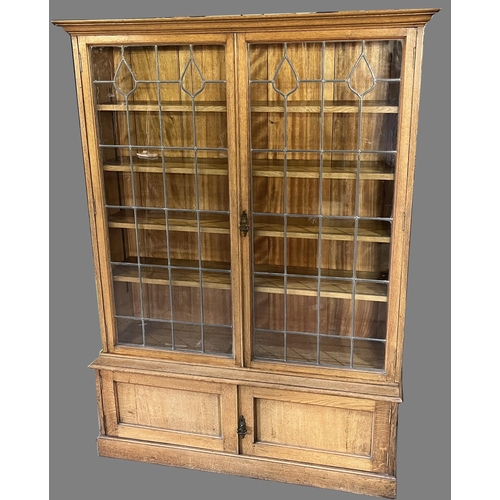 1330 - Edwardian golden oak bookcase, moulded cornice above a pair of lead glazed doors enclosing four adju... 