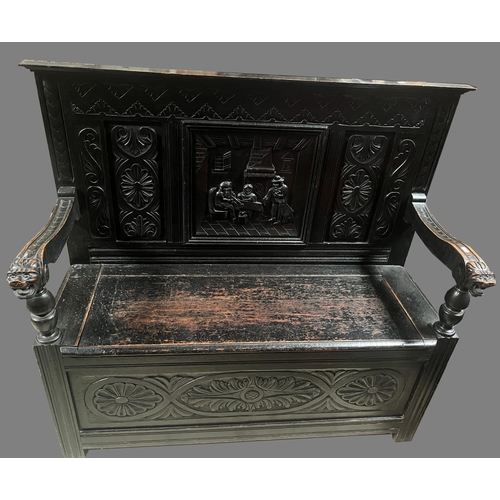 1332 - 17th century style ebonised oak box settle, with figural and scroll carved panel back, mask head arm... 