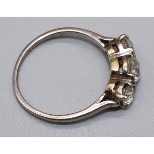 1016 - White metal three stone diamond ring, the central round cut diamond in split bezel setting, flanked ... 