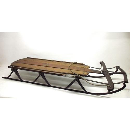 1387 - 'Flexible Flyer' articulated sledge, stained oak and cast iron, L151cm