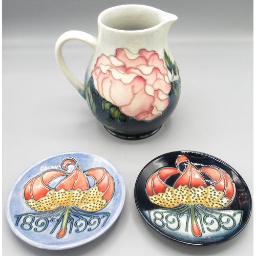 Moorcroft Pottery: 'Roses' design jug produced for M.C.C, H14.5cm, and two M.C.C. Centenary pin dishes, both D11.5cm (3)