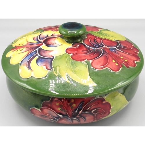 Moorcroft Pottery: 'Hibiscus' pattern circular trinket pot and cover, purple and yellow flowers on green ground, D12cm