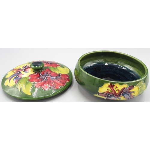 567 - Moorcroft Pottery: 'Hibiscus' pattern circular trinket pot and cover, purple and yellow flowers on g... 