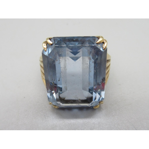 27 - 9ct yellow gold ring set with large emerald cut blue stone, 9.6g