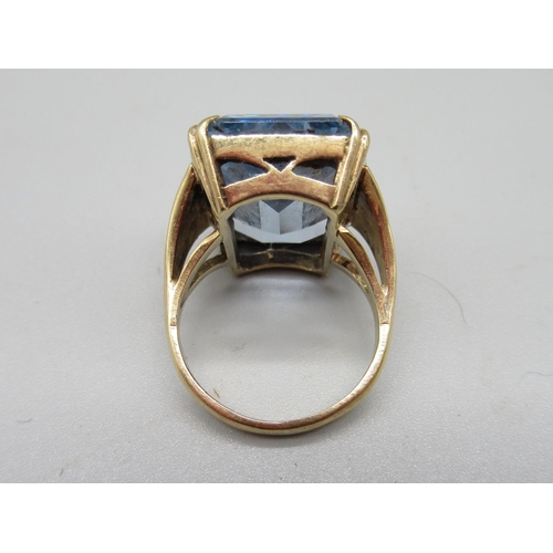 27 - 9ct yellow gold ring set with large emerald cut blue stone, 9.6g