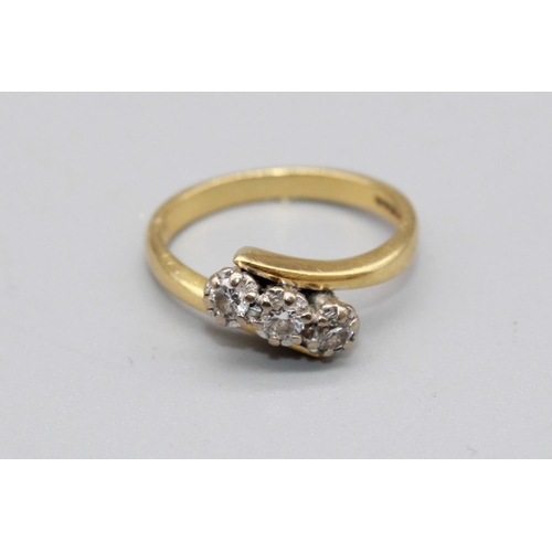 49 - 18ct yellow gold cross over three stone diamond ring, the diamonds illusion set, stamped 750, size L... 
