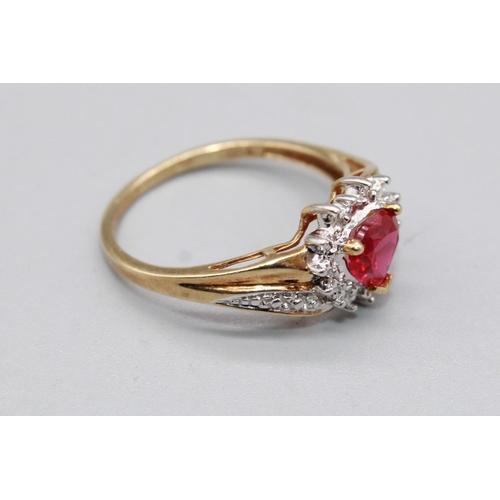 79 - 10ct yellow gold ring set with ruby heart cut stone surrounded by a halo of diamonds, on diamond twi... 