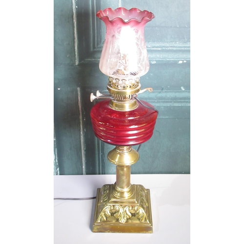 281 - 20th century brass oil lamp, with red glass reservoir and cranberry tint etched shade, now converted... 