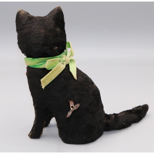 626 - Seated clockwork cat, black mohair with green ribbon, mouth opens and tail twitches, H15.5cm