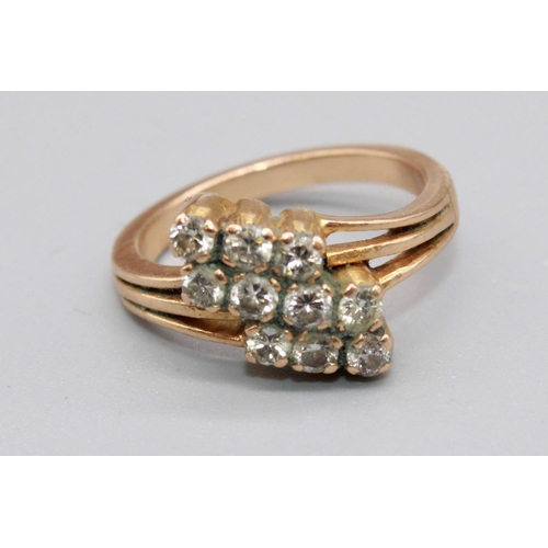 100 - Yellow metal ring set with three rows of brilliant cut diamonds, on cut-out shoulders, unmarked, siz... 