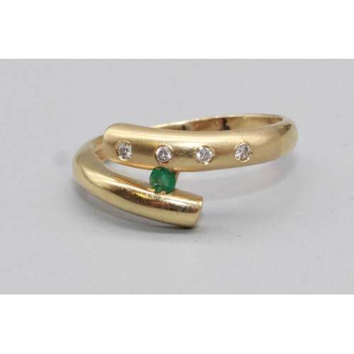 77 - 14ct yellow gold cross over ring set with brilliant cut diamonds and a brilliant cut emerald, stampe... 