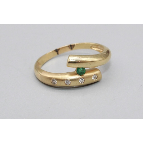 77 - 14ct yellow gold cross over ring set with brilliant cut diamonds and a brilliant cut emerald, stampe... 