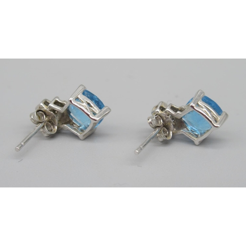 705 - 9ct white gold single stone blue stone ring, stamped 375, and a pair of matching earrings stamped 9k... 