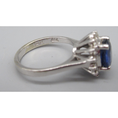 67 - 18ct white gold sapphire and diamond cluster ring, the central oval cut sapphire surrounded by a hal... 