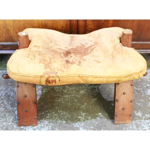 320 - 20th century camel saddle, dished seat and leather cushion on curved supports, W68cm