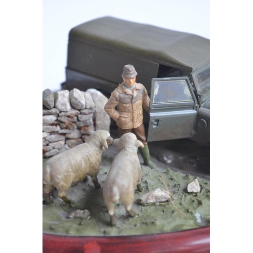 185 - Two well presented farming related dioramas to include resin/ceramic grey tractor with resting drive... 