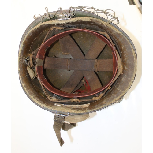 1128 - American WW2 M1 Helmet, complete with liner, camouflage netting, and a wound dressing.