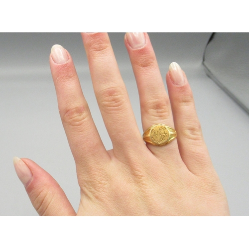 1024 - 18ct yellow gold signet ring with engraved initials to round face, stamped 18, size J1/2, 6.4g