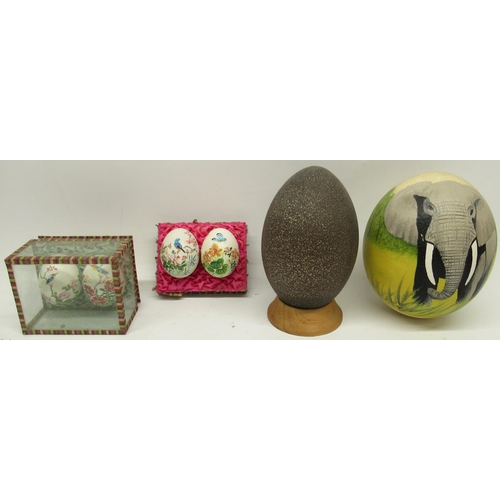 1124 - Decorated ostrich eggs, on turned wooden stand, 14cm and other decorated eggs