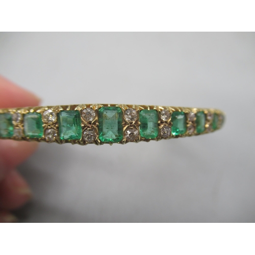 1001 - 15ct yellow gold hinged bangle set with graduated emeralds cut emeralds and brilliant cut diamonds, ... 