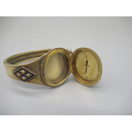 1002 - Victorian yellow metal and blue enamel mourning bangle set with pearls, the centre opening to reveal... 