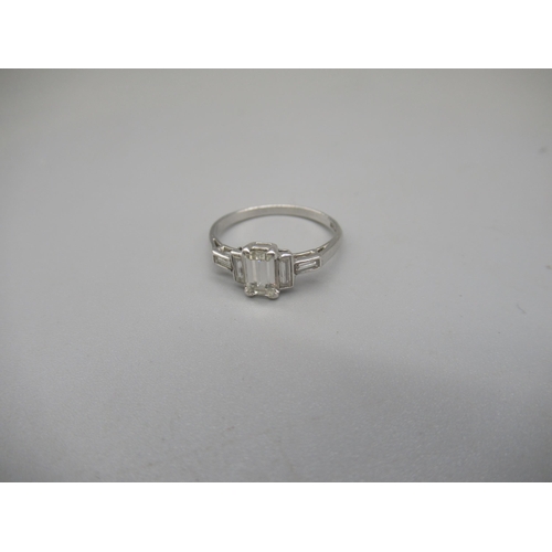 1011 - Platinum ring set with central emerald cut diamond, flanked by two baguette cut diamonds, stamped Pl... 