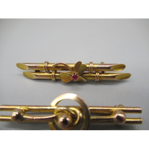 1004 - 9ct yellow gold bar brooch set with clover with ruby to centre, and another 9ct bar brooch with circ... 