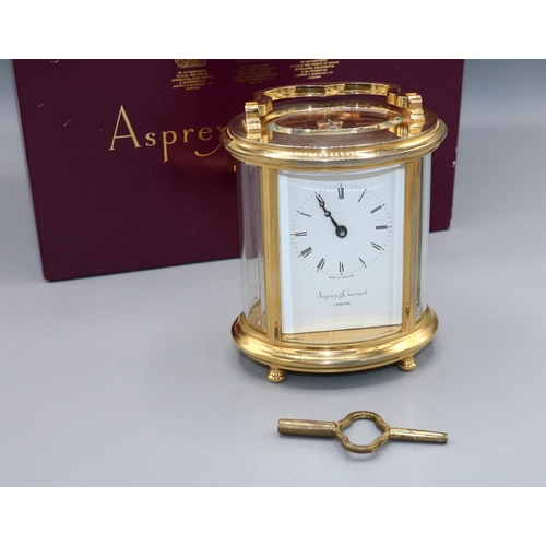 1095 - Asprey & Garrard London, 8 day oval brass carriage clock timepiece, signed white enamel Roman dial, ... 