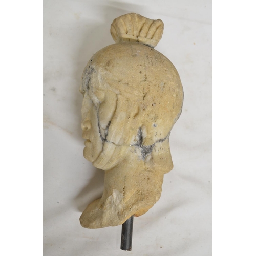32 - Carved marble head of a Roman soldier, damaged and pieced back together. With vertical stand rod, no... 