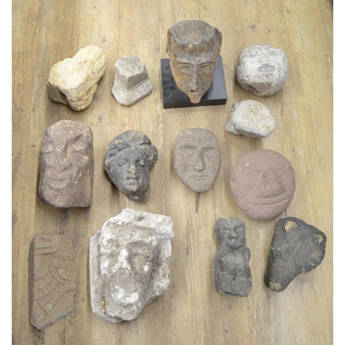 50 - Collection of carved stoneware to include faces, a wolf head, one composite head on plinth, etc. (13... 