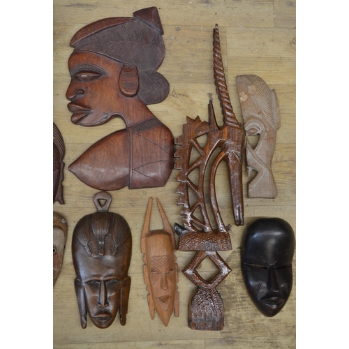 91 - A large collection of wooden masks and carvings of various ages and styles, originating from across ... 