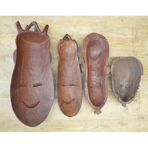 92 - A selection of four carved wooden masks of various styles and time-periods, most likely originating ... 