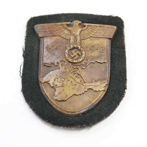 243 - Wehrmacht Krim Campaign Shield(Crimea) Complete with prongs and original cloth backing.