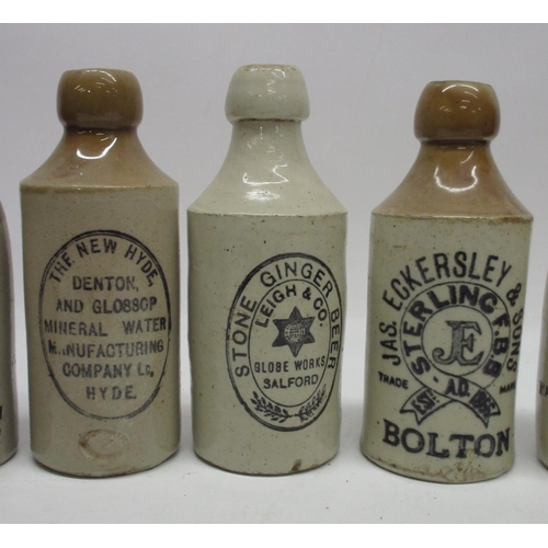 205 - A collection of fifteen stoneware ginger beer and stout bottles from the Manchester area, including ... 