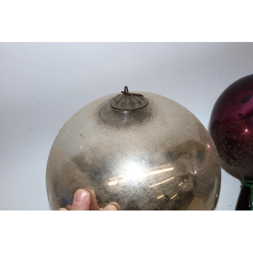 1261 - Four mercury glass witches balls, the larger two balls with inset metal hangers, max. D21cm