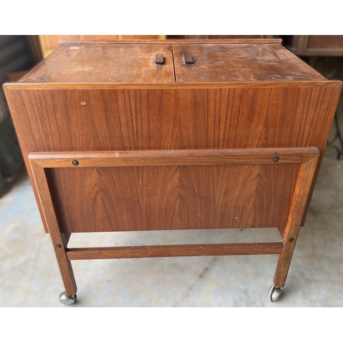 603 - Mid 20th century teak drinks trolley, hinged top revealing internal shelf and five bottle compartmen... 