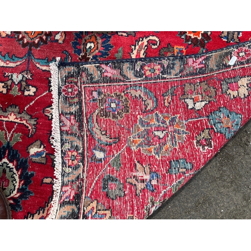 1294 - Persian red ground floral pattern rug, 180cm x 160cm