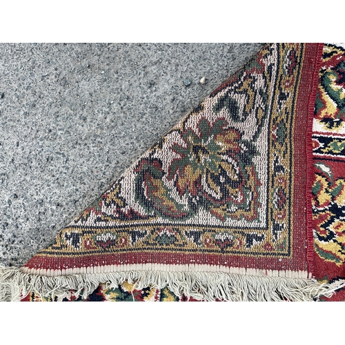 1295 - Belgian Persian pattern red ground rug, 265cm x 175cm